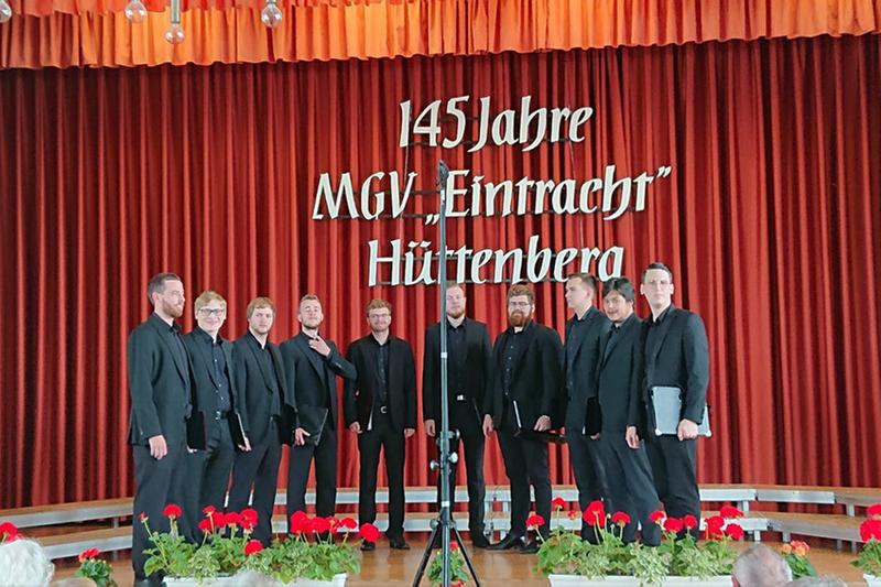Das Foto zeigt die 10 Sänger von Principium Canti auf der Bühne beim Chorwettbewerb anlässlich der 145 jährigen Jubiläums des MGV